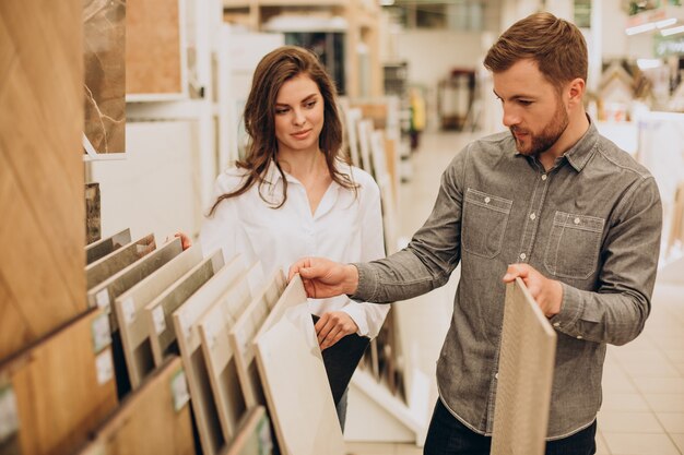 Young couple choosing tiles at building market