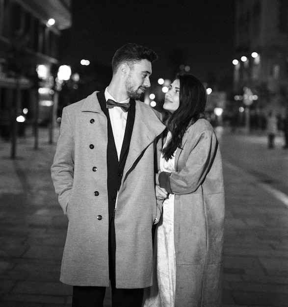 Free photo young couple in coats standing in street