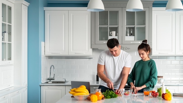 Молодая пара готовит дома