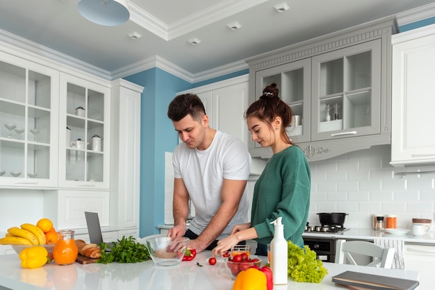 Foto gratuita giovani coppie che cucinano a casa