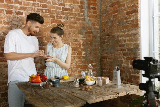 Young couple cooking and recording live video for vlog and social media