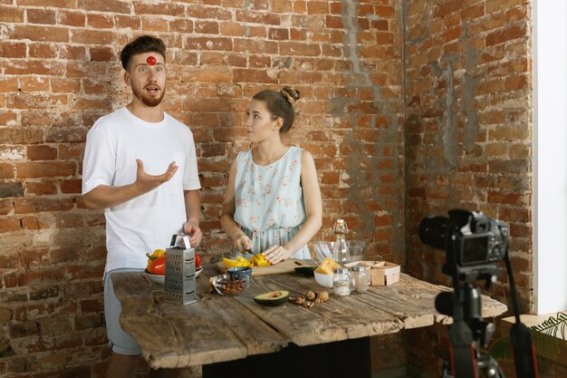 Young couple cooking and recording live video for vlog and social media