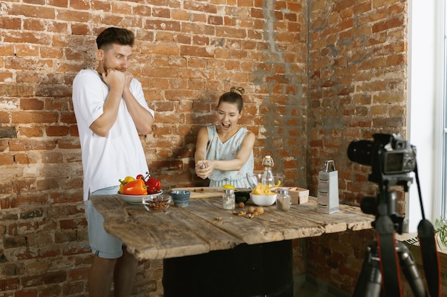 Young couple cooking and recording live video for vlog and social media