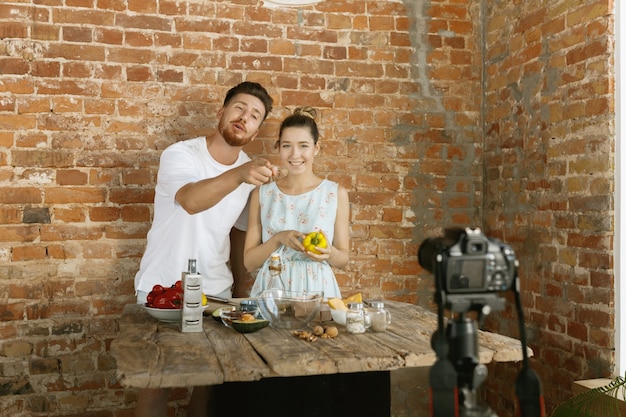 若いカップルがvlogやソーシャルメディアのライブビデオを料理して録画する