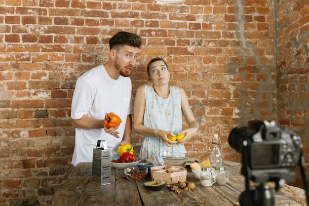 Young couple cooking and recording live video for vlog and social media