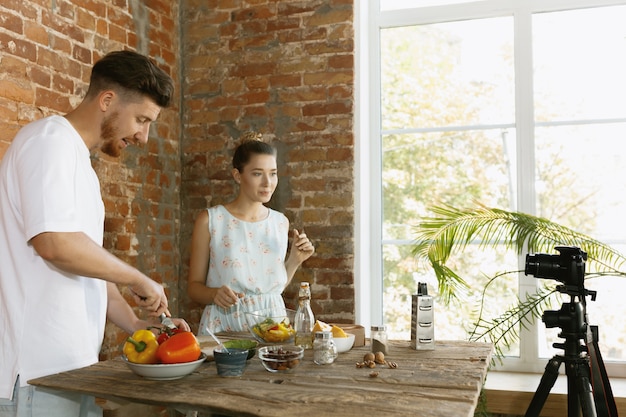 Giovane coppia che cucina e registra video dal vivo per vlog e social media