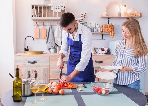 Young couple cooking salad in kitchen