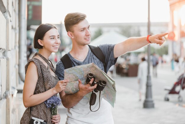 Free photo young couple discovering city with map