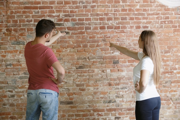 Young couple doing apartment repair together themselves. Married man and woman doing home makeover or renovation