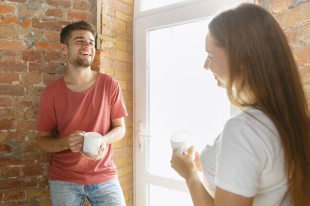 一緒にアパートの修理をしている若いカップル。家のイメージチェンジやリフォームをしている既婚男性と女性