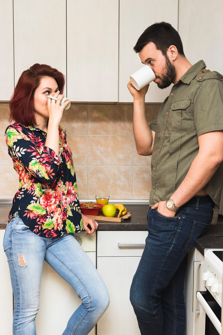 मुफ़्त फोटो young couple drinking tea in domestic kitchen