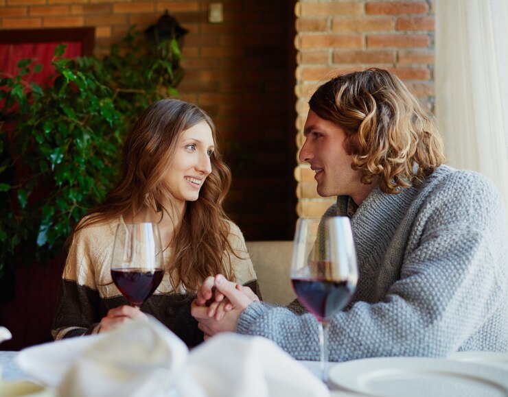 Free Photo young couple drinking wine in a bar
