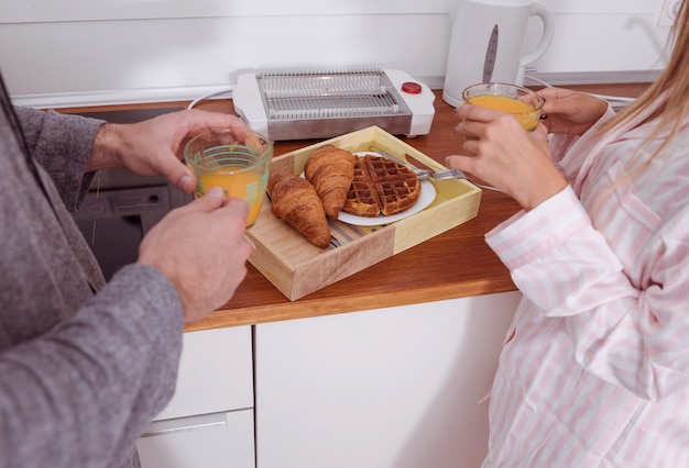 Foto gratuita giovani coppie che mangiano prima colazione in cucina