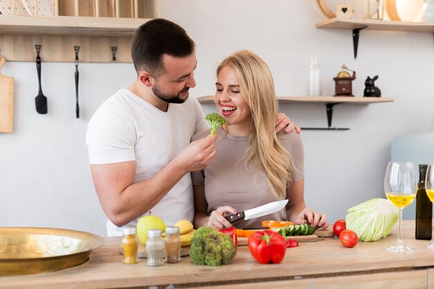 Young couple eating broccoli
