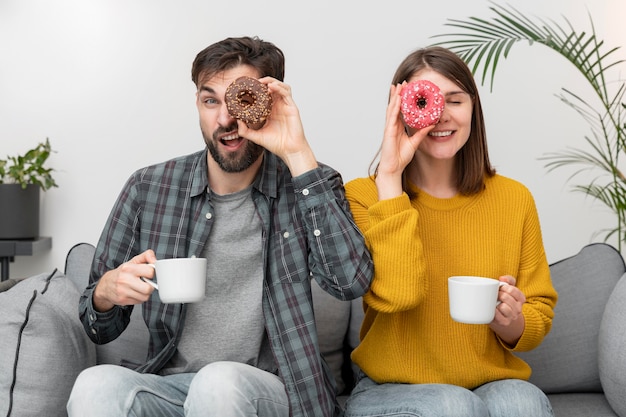 Young couple eating donuts