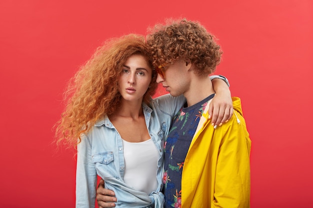 young couple embracing each other at studio wall