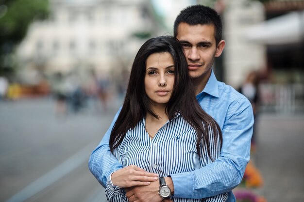 "Young couple embracing on street"