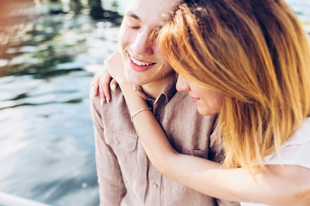 Young couple embracing at water