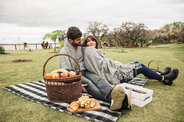 Молодая пара, наслаждаясь на пикнике в парке