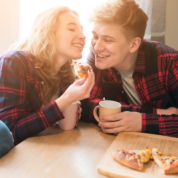 Giovani coppie che godono della pizza