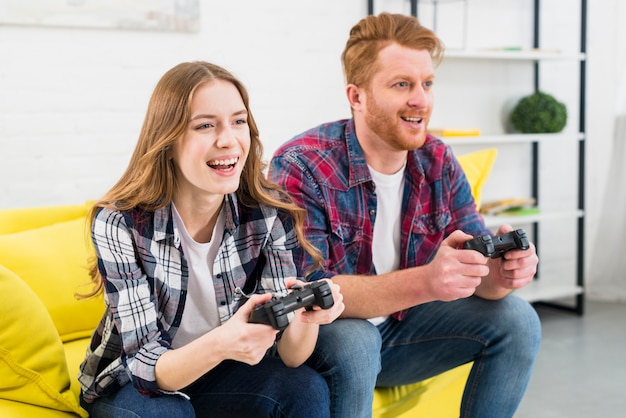 Young couple enjoying playing video game together at home