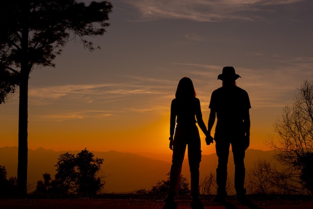 Free photo young couple enjoying the sunset in the mountain