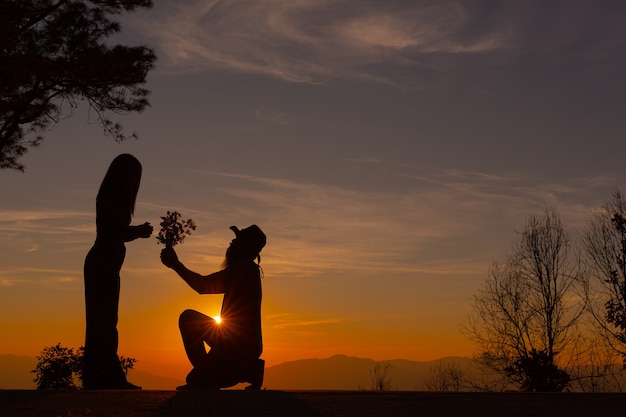 Young couple enjoying the sunset in the mountain