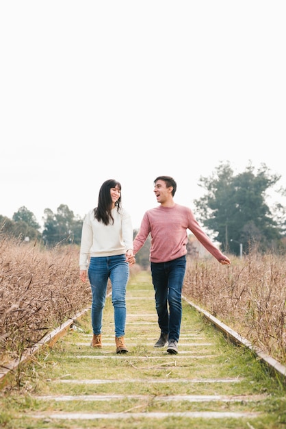 Young couple enjoying walk along tracks