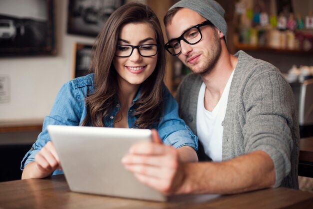 Young couple enjoying wireless internet at restaurant. D