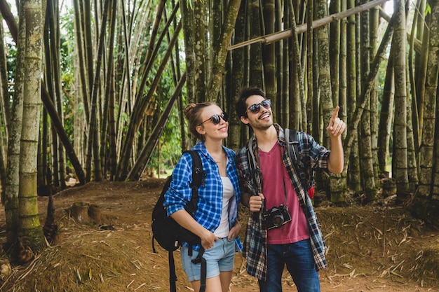 Free photo young couple exploring forest