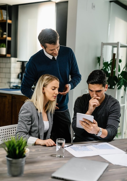 Free photo young couple feeling uncertain while using digital tablet on a meeting with their insurance agent at home