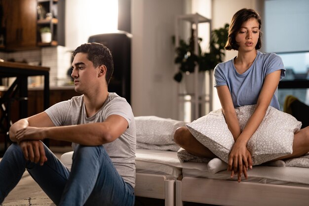 Молодая пара чувствует себя несчастной в своих отношениях и игнорирует друг друга после ссоры в спальне