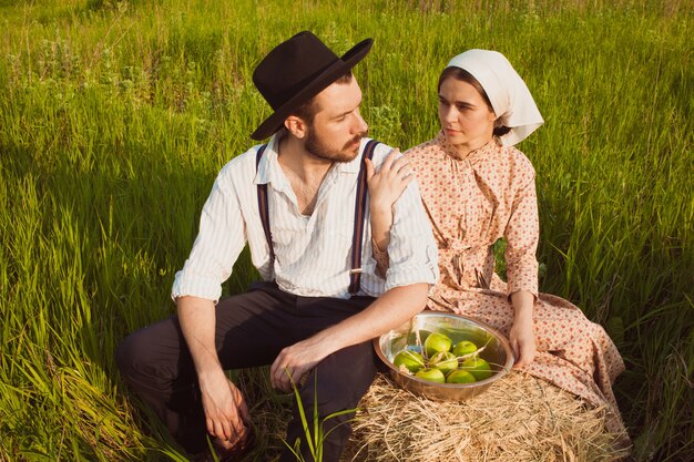 Young couple in the field with apples