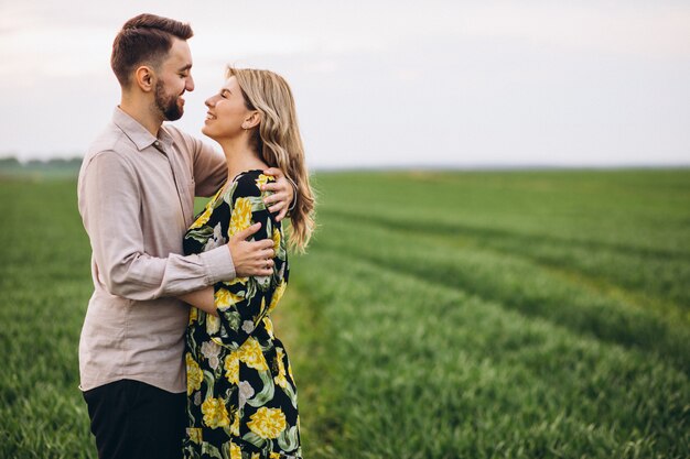 young couple in the field with green grass