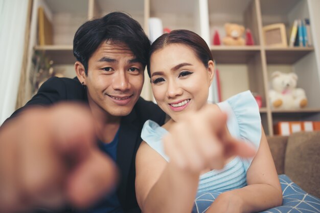 Young couple finger point to camera