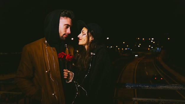 Young couple in garland in dark street