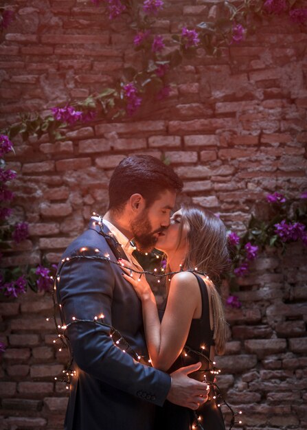 Young couple in garland kissing 