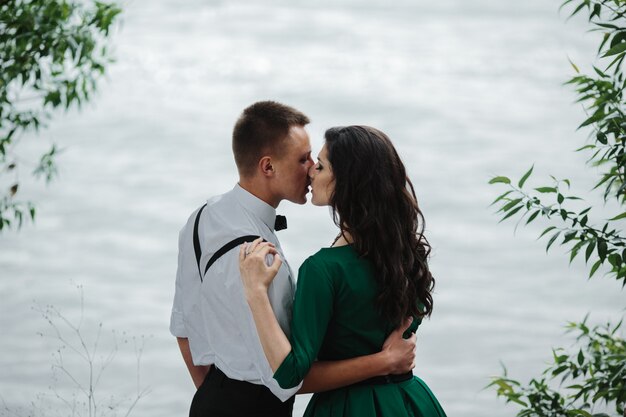 若いカップル湖の隣にキスを与えます