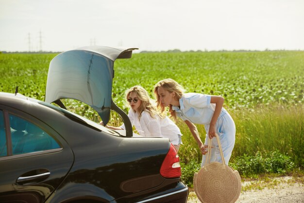 Young couple going to vacation trip on the car in sunny day