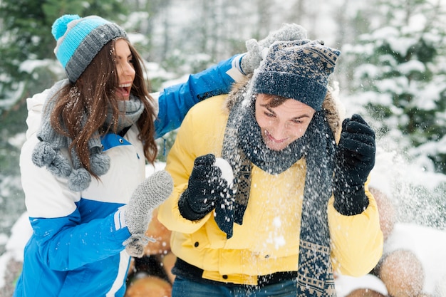 若いカップルは雪合戦中に楽しんでいます