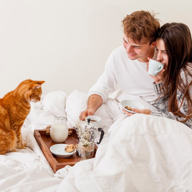 Young couple having breakfast in bed