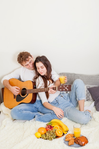 Young couple having breakfast in bed