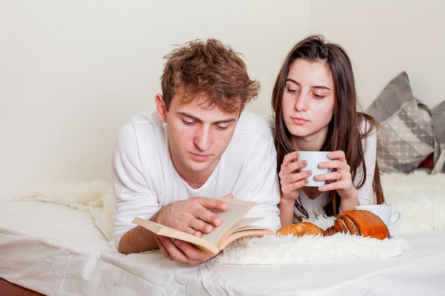Foto gratuita giovane coppia facendo colazione a letto