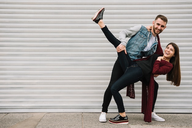 Young couple having fun in front of garage