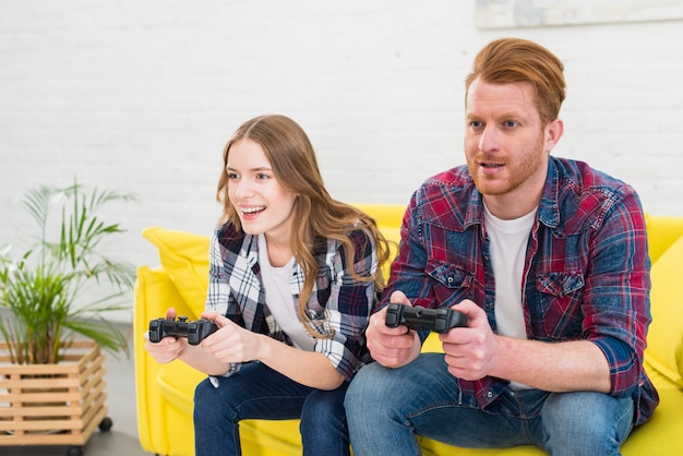 Young couple having fun playing videogame at home