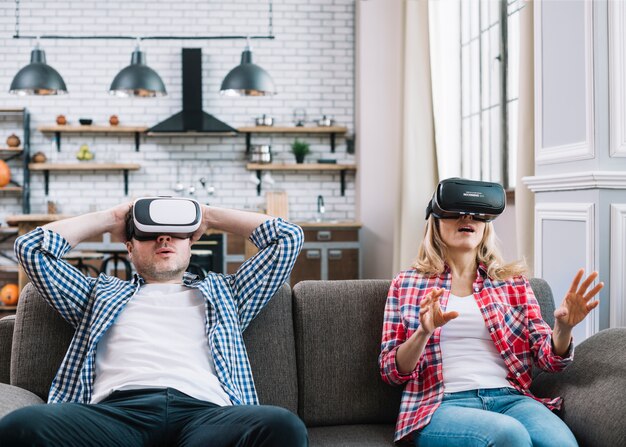 Young couple having fun together with virtual goggle in home