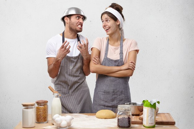 キッチンで料理をしながら喧嘩を持っている若いカップル。