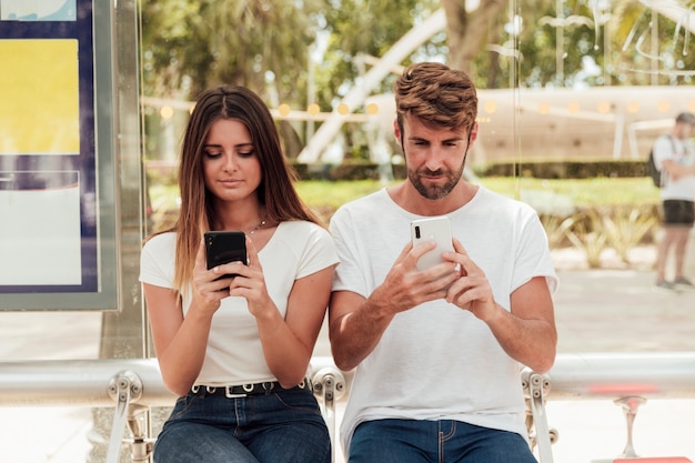Young couple holding cell phones