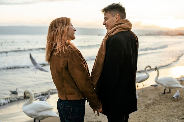 Young couple holding hands on the beach in winter