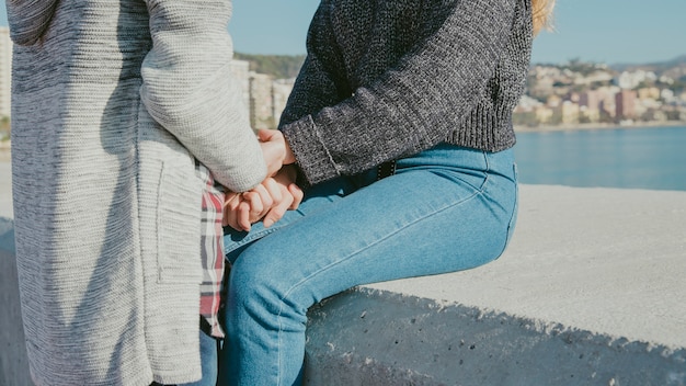 Young couple holding hands in front of sea